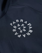 Close-up of a dark navy garment featuring a circular white 'PARRAPARRA' logo printed on the chest.