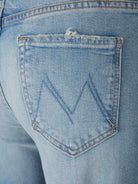 Close-up of a blue denim pocket with a brand logo.