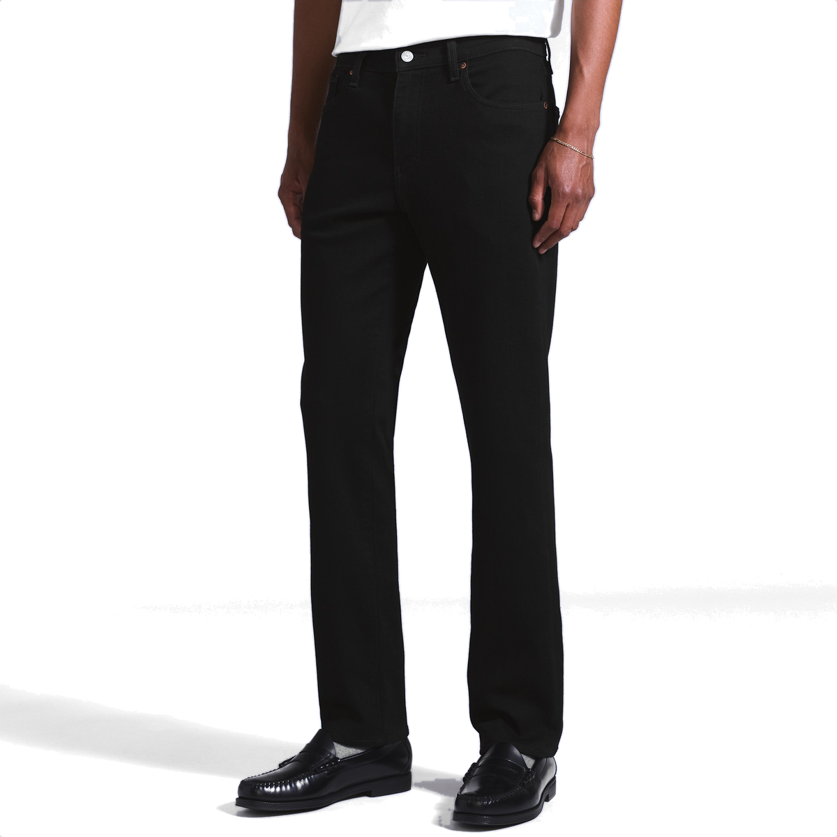 Model wearing black Levi’s 511 Slim Jeans with a white T-shirt and black penny loafers, showing the slim straight leg from waist to hem.