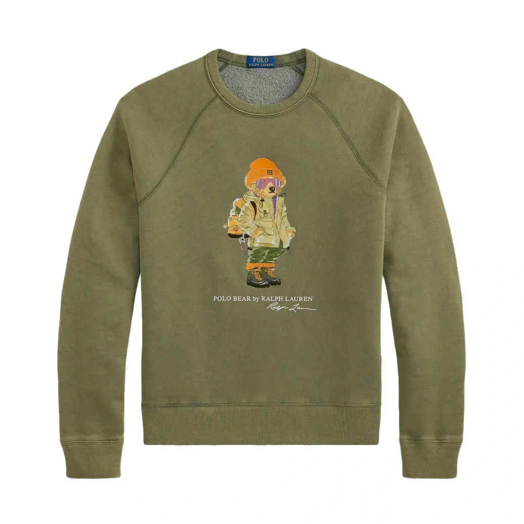 Polo Ralph Lauren Red Rock Crewneck laid flat. An olive green raglan sweatshirt with a Polo Bear graphic in an orange beanie, ski goggles, a parka and hiking boots.