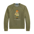 Polo Ralph Lauren Red Rock Crewneck laid flat. An olive green raglan sweatshirt with a Polo Bear graphic in an orange beanie, ski goggles, a parka and hiking boots.