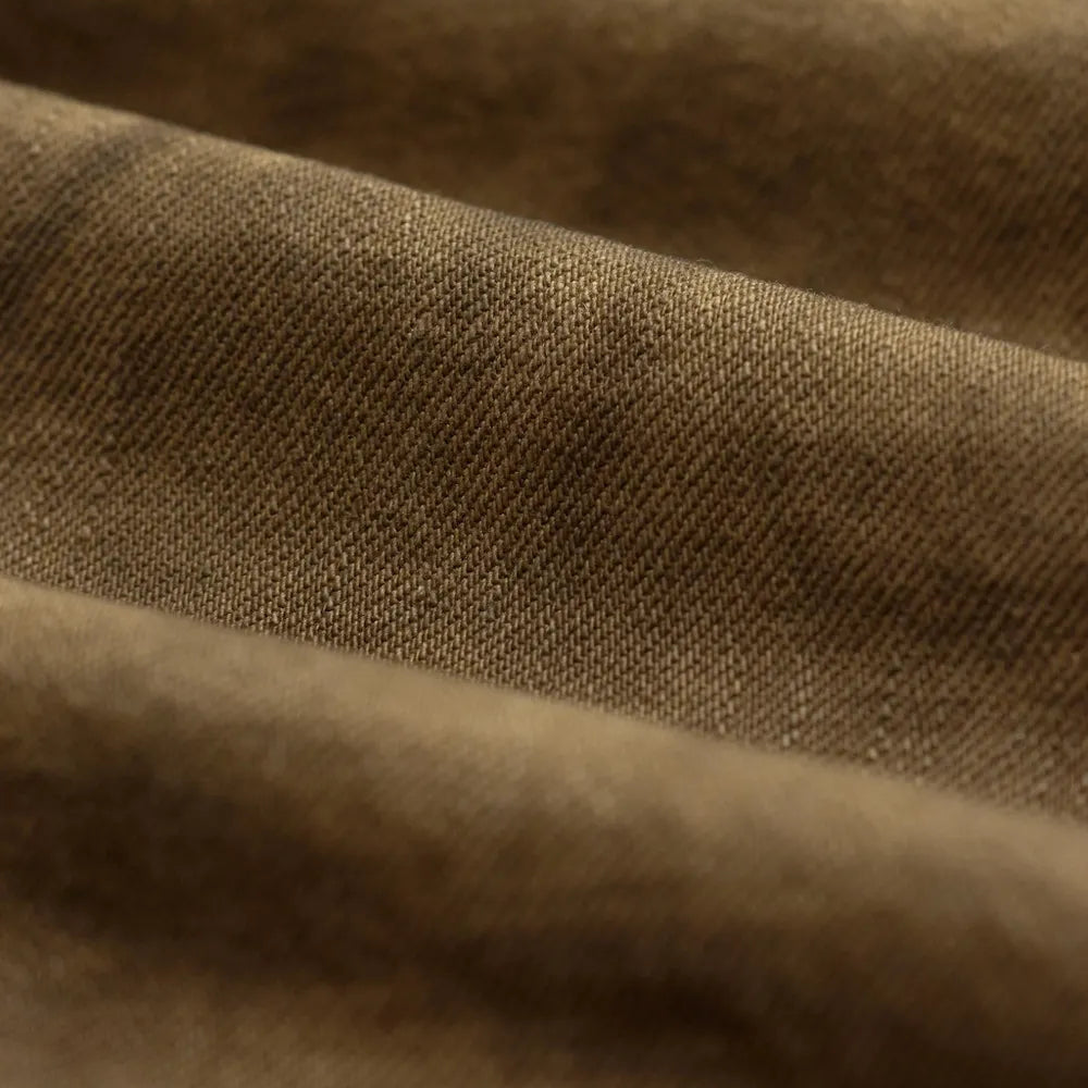 A close-up of draped brown fabric with a fine woven texture and soft folds.