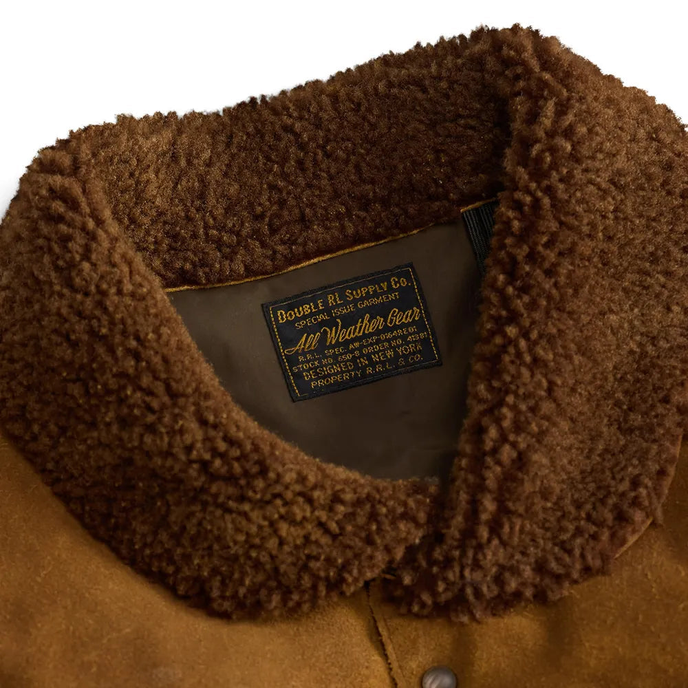 Close-up of a black puffer jacket with a brown suede yoke and a brown sherpa collar, shown flat on a white background.