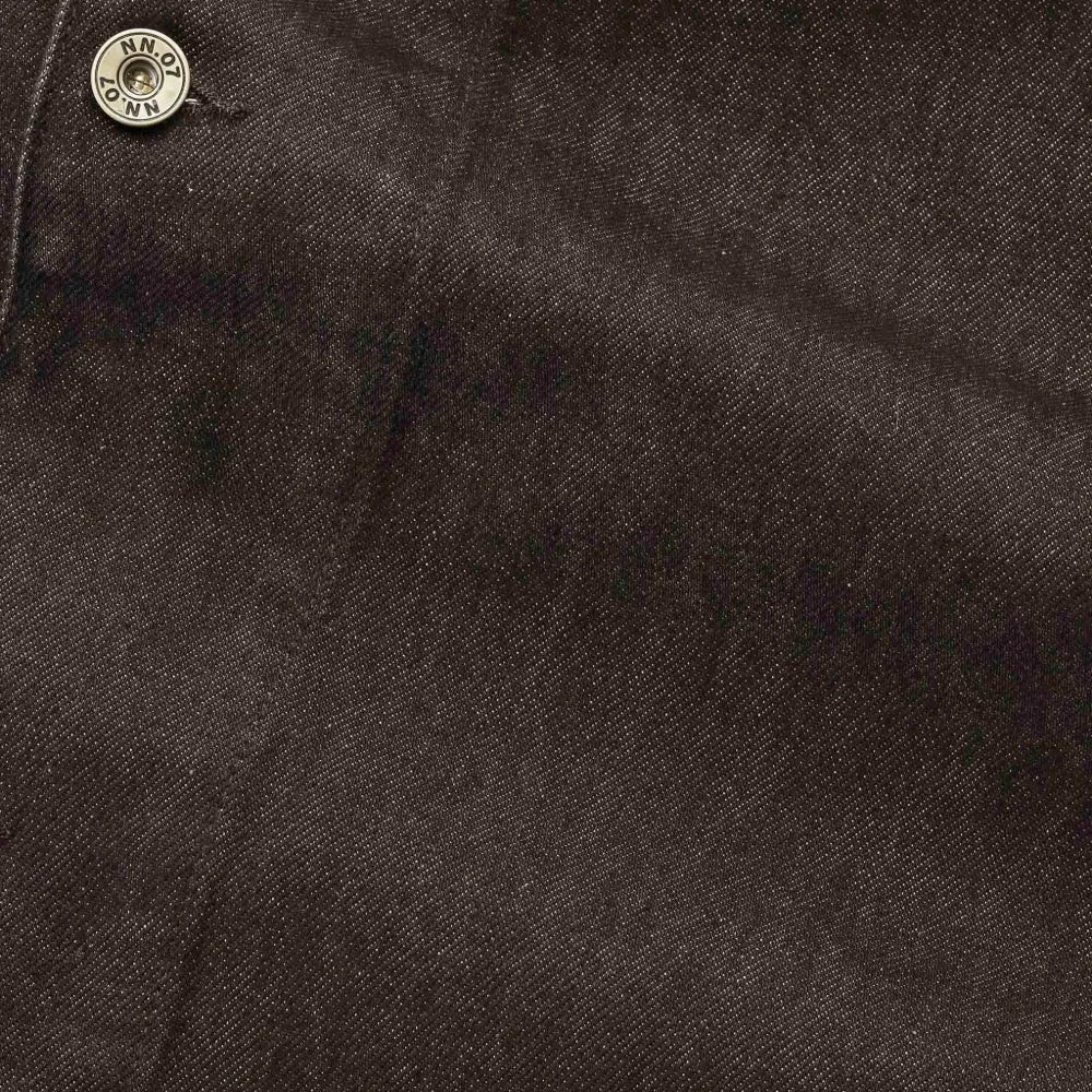 Close-up of dark brown textured fabric with a small metallic snap button at the top left corner.