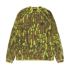 Front view of the Stüssy Basic Stüssy Thermal in tree bark camo laid flat. A long-sleeve waffle-knit top in a lime, olive and brown camo print, with raglan sleeves, lime contrast stitching and a small black Stüssy logo on the chest.
