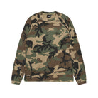 Front view of the Stüssy Basic Stüssy Thermal in woodland camo laid flat. A long-sleeve waffle-knit top in olive, tan, brown and black camo with raglan sleeves and a small black Stüssy logo on the chest.