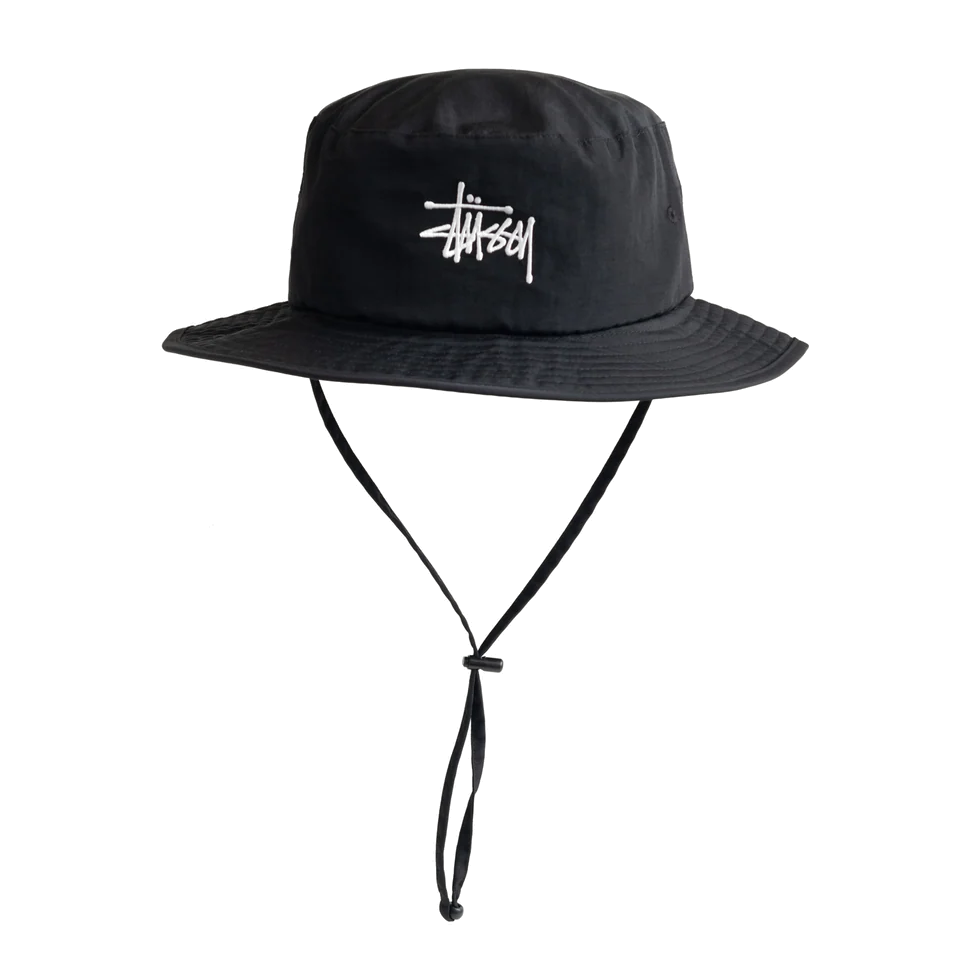 Front view of a black nylon Stüssy Basic Boonie Hat with a wide brim, the Stüssy logo embroidered in white on the crown, and an adjustable chin strap with a bead keeper.