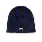 A fuzzy knit beanie hat featuring a dark blue and black leopard print pattern with a small white Stüssy logo embroidered on the front, set against a plain white background.
