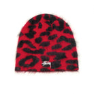 A red and black fuzzy beanie hat with a small white Stüssy logo on the front, set against a plain white background.
