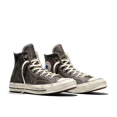 Pair of black Converse Chuck 70 Hi Burnished Leather sneakers at a front three-quarter angle, showing the distressed toe caps and the ankle patch.