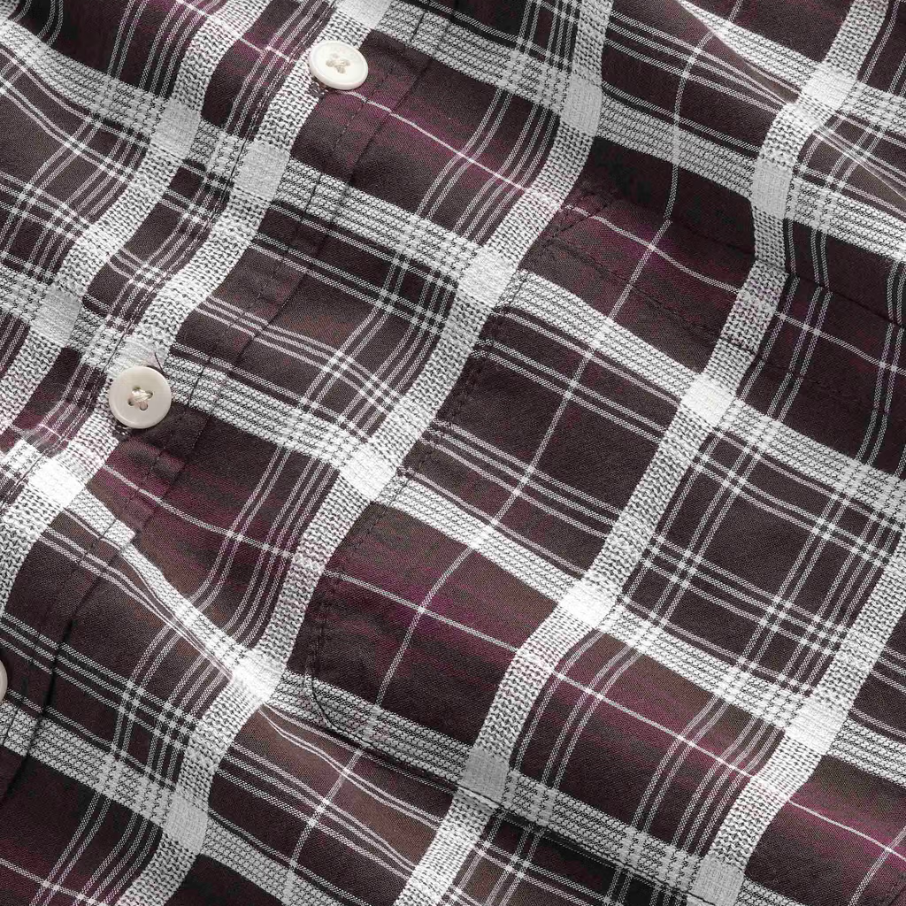 Close-up of a plaid button-up shirt fabric in dark burgundy with white and thin pink stripes, showing the texture and pattern details.