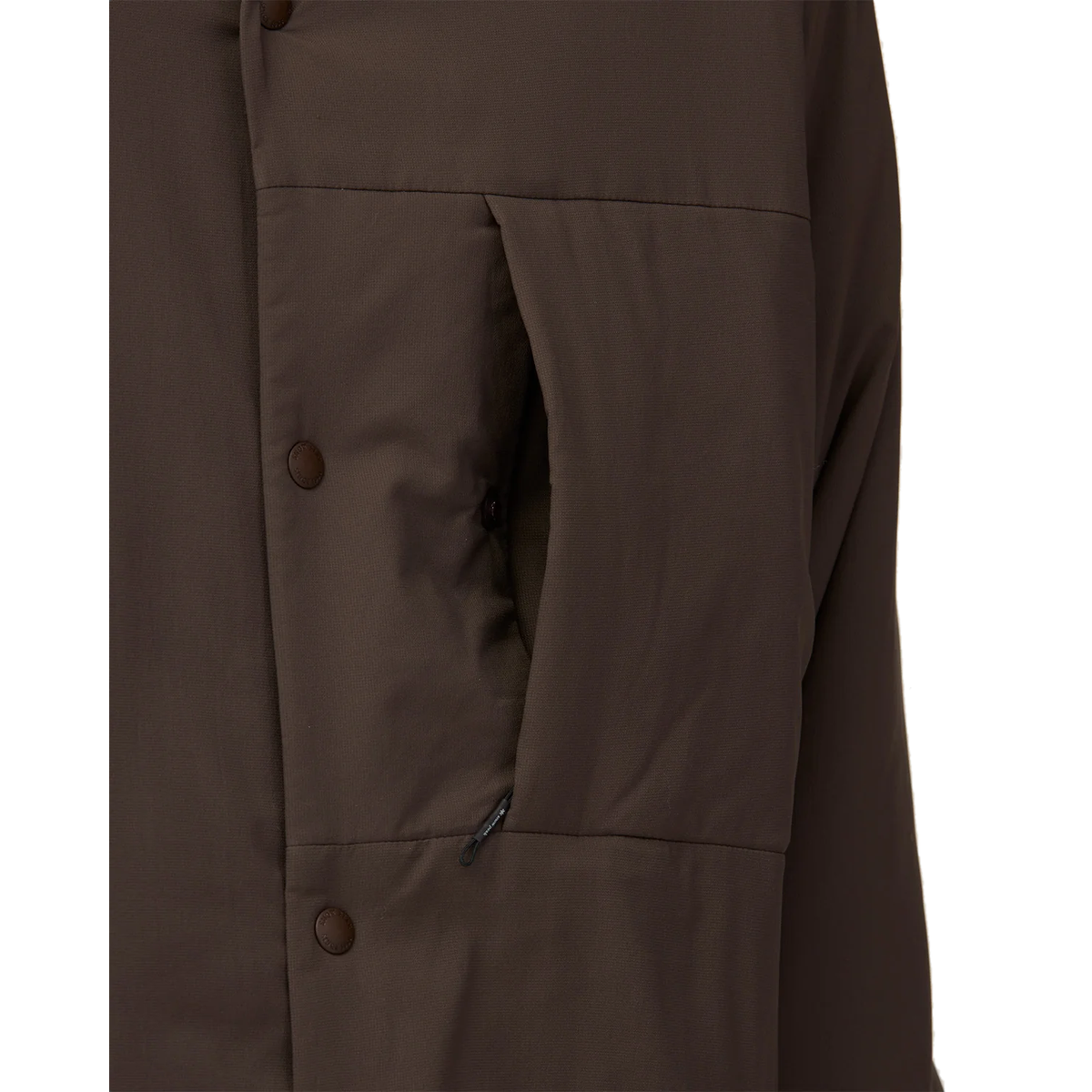 Chest Pocket Detail: Close-up of the open chest pocket on a dark brown Snow Peak Flexible Insulated Cardigan, showing the small zip pull inside the pocket and the snap buttons along the front.