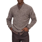 A man modeling a gray and black marled knit sweater over a patterned collared shirt, paired with dark brown trousers and black shoes, against a white background.