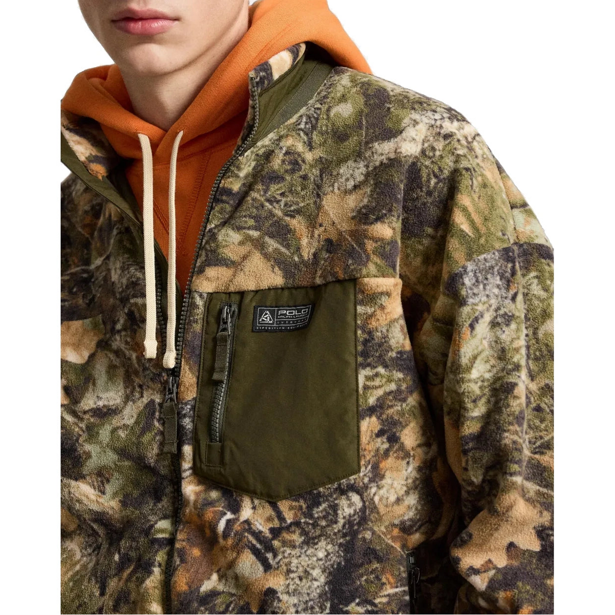 Close-up of the Forest Print Fleece Jacket, showing the olive zippered chest pocket with its Polo Ralph Lauren Outdoors “Expedition Equipment” patch and the leaf-print fleece.