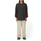 Full-length view of a model wearing the charcoal Snow Peak Heavyweight Waffle Pullover with beige wide-leg pants and dark trail shoes.
