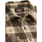 Close-up of a RRL plaid flannel shirt in brown and beige with a small leaf pattern, featuring a button-down front and a visible RRL neck label.