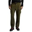 A person wearing olive green cargo pants with side flap pockets, paired with a black sweater and black shoes with red laces, shown against a plain white background.
