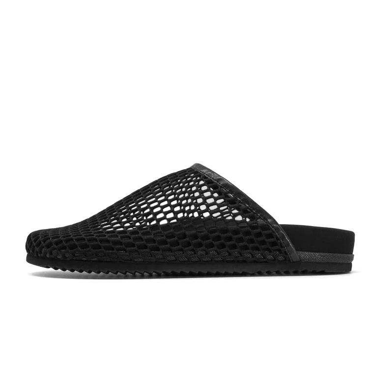 Side view of the ROAM Mesh Clog in black on white, showing the open mesh upper, vegan leather trim, backless heel and treaded black sole.