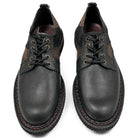 Top-down view of the pair, showing the lace-up fronts with brass eyelets, the patchwork upper and the red contrast stitching on the welt.