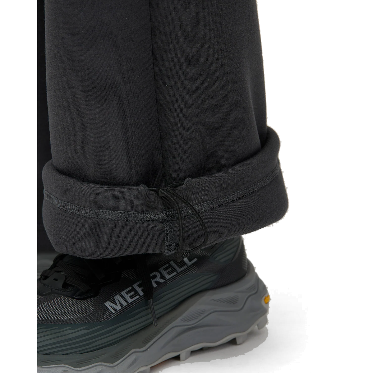 Close-up of the rolled hem on charcoal Snow Peak Odor Control Women’s Pants, showing the elastic drawcord and toggle above a trail shoe.