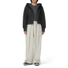 Full-length view of a model wearing the charcoal Snow Peak Odor Control Women’s Zip Parka open over a grey top, with off-white wide-leg pleated pants and grey trail shoes.