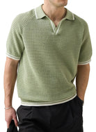 Man wearing a green patterned polo shirt and sunglasses against a white background
