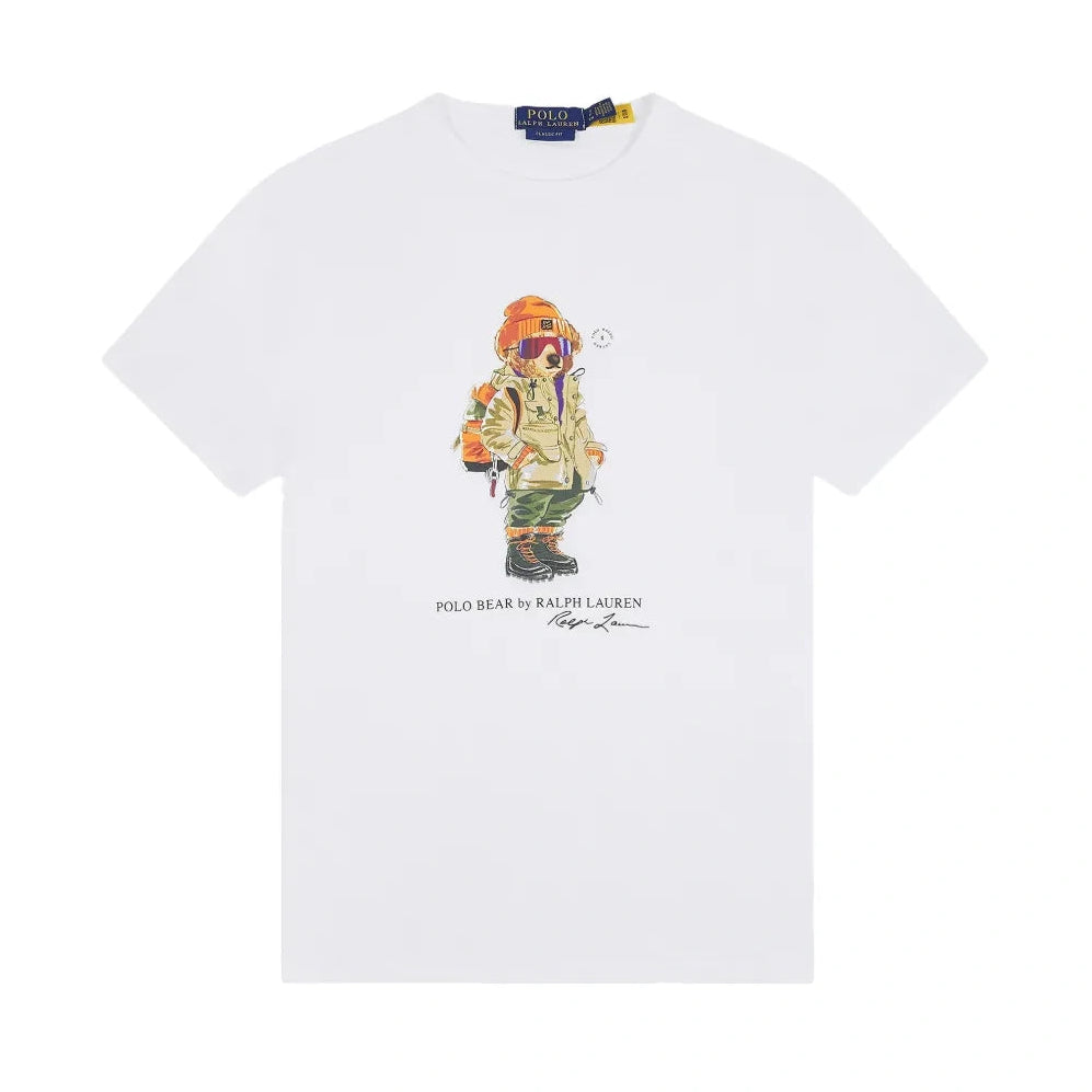 Polo Ralph Lauren Polo Bear Jersey T-Shirt laid flat. A white crewneck tee with a Polo Bear graphic in an orange beanie, ski goggles, a khaki parka and boots, with “Polo Bear by Ralph Lauren” below.