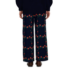 Back view of a model wearing The Tiny Big Sister Roses Grid Embroidery Berta Long Jeans with a navy knit sweater and brown loafers, showing the rose embroidery on the back.