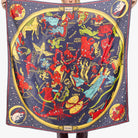 Person holding a large scarf with zodiac design against a white background