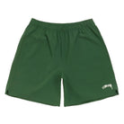 Front view of the Stüssy Sport Short in pine laid flat. Dark green shorts with an elastic waist, split side hems and a cream Stüssy script logo on the leg.