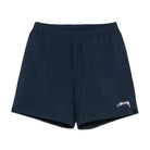 Front view of the Stüssy Sport Short in navy laid flat. Navy shorts with an elastic waist, split side hems and a cream Stüssy script logo on the leg.
