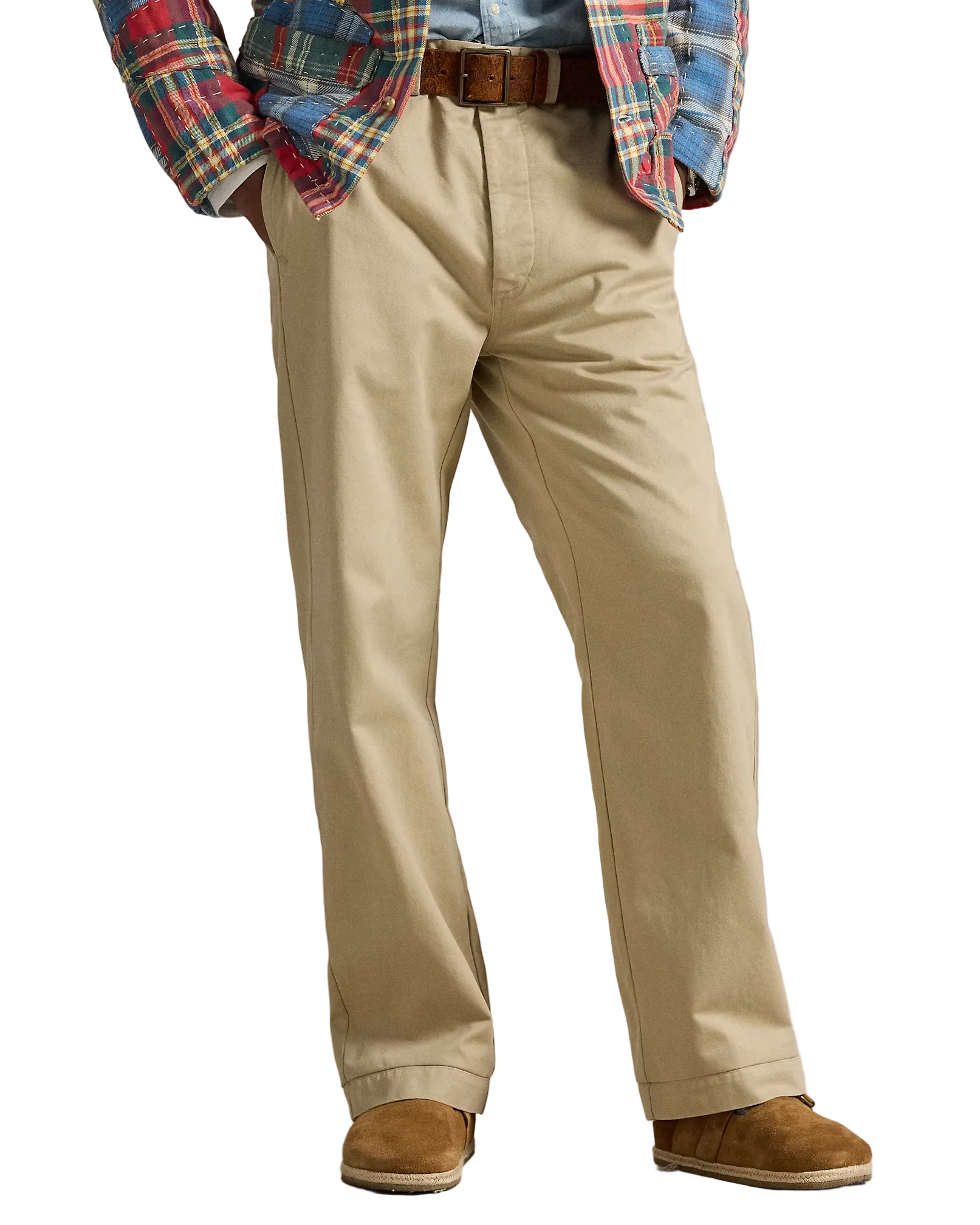 Person wearing beige pants with a plaid shirt and brown shoes on a neutral background